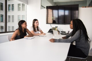 3 women gathering around table